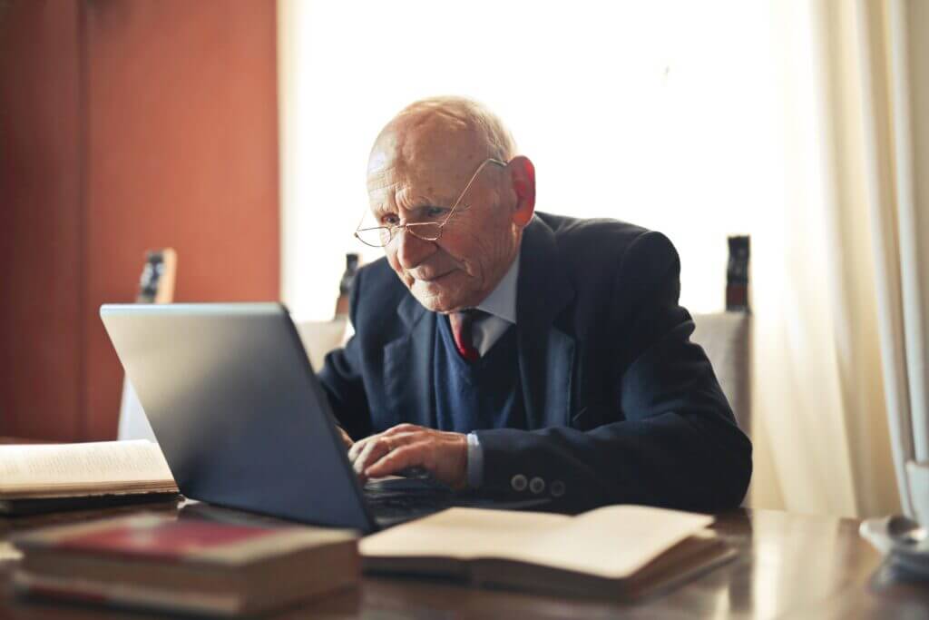 Пожилой мужчина работает за ноутбуком